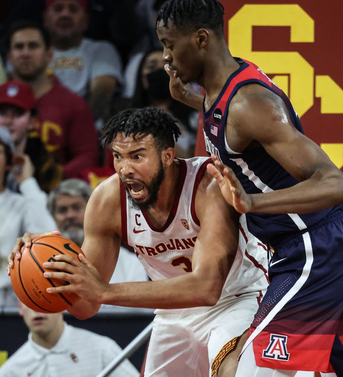USC forward Isaiah Mobley secures a rebound in front of Arizona center Christian Koloko.
