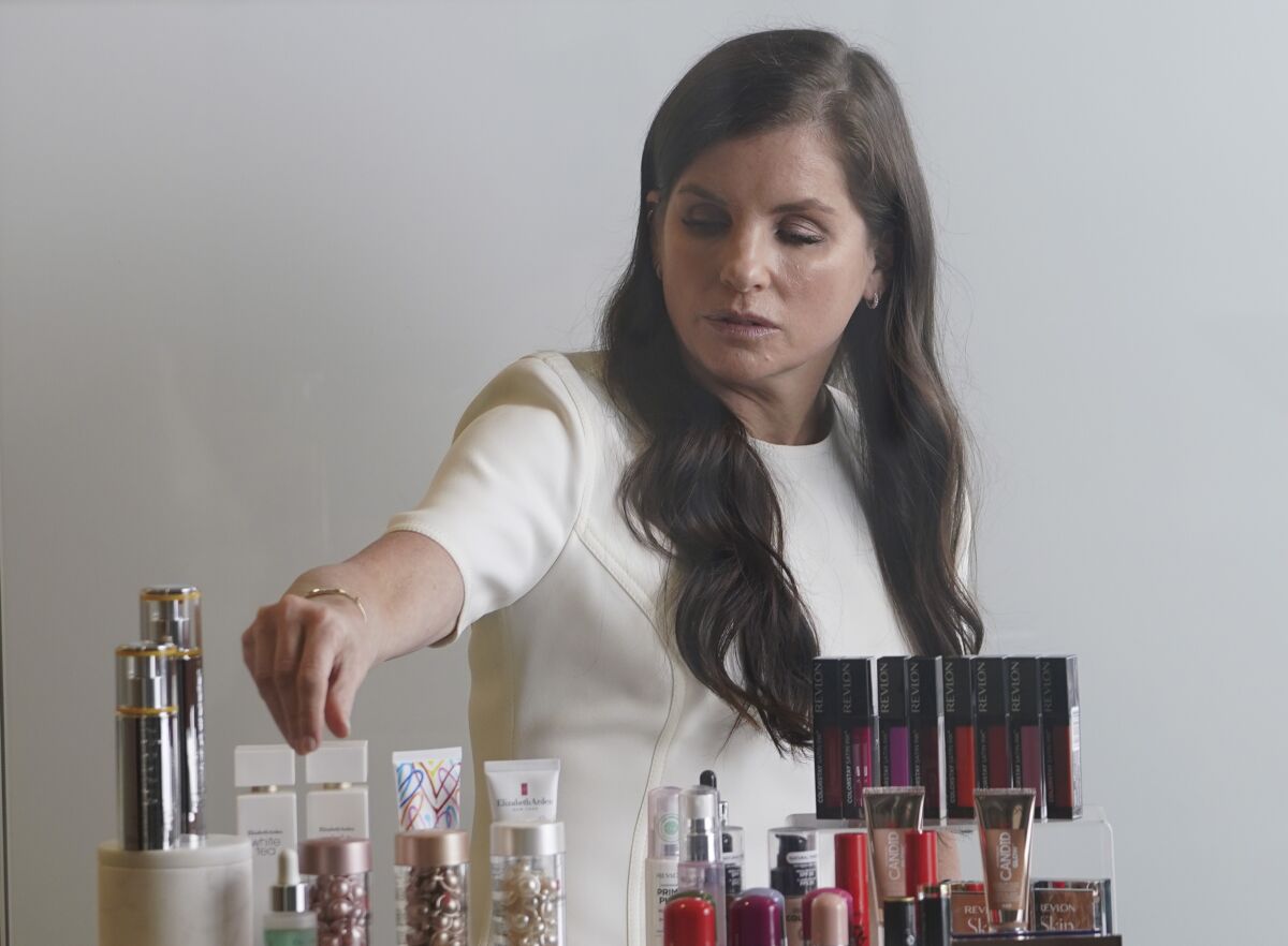 Revlon CEO Debra Perelman, the company's first woman CEO in its 89-year-old history, show products during an interview, Wednesday Aug. 18, 2021, in New York. Revlon was already facing big challenges when Perelman took over as the first woman CEO in its 89-year-old history in 2018. But Perelman says she is optimistic about the brand's future, pointing to steps she has taken to accelerate e-commerce and being more nimble in the face of competition. (AP Photo/Bebeto Matthews)