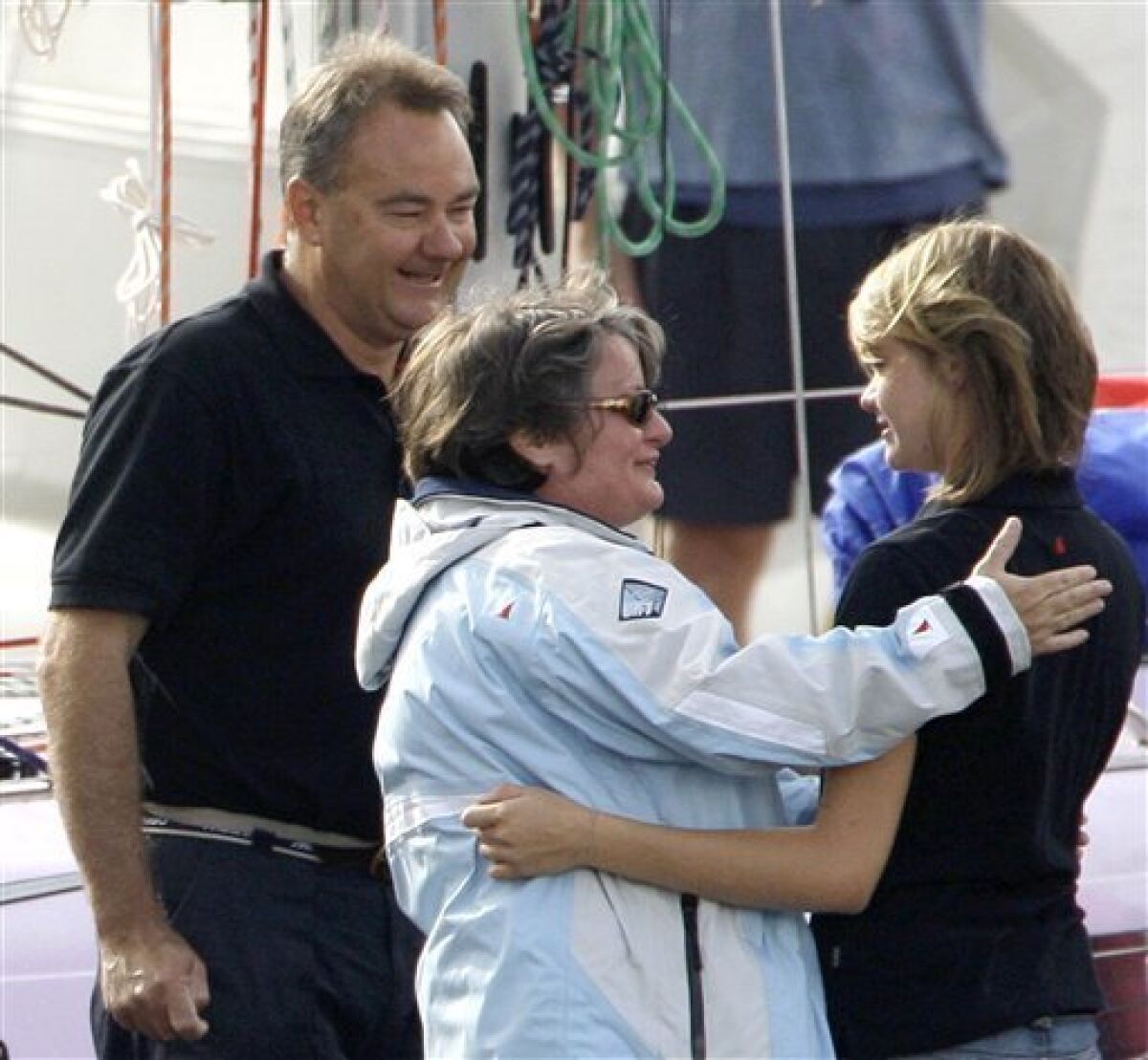 In this file photo from Oct. 18, 2009, teenage sailor Jessica Watson, right, hugs her mother Julie as her father, Roger, looks on as she prepares to depart Sydney on her boat Ella's Pink Lady in an attempt to become the youngest person to sail non-stop, solo and unassisted, around the world. Thousands are expected to line Sydney Harbour on Saturday, May 15, 2010, to offer a hero's welcome to 16-year-old Jessica Watson, who has battled 40-foot (12-meter) waves, multiple knockdowns and critics who called her too immature and inexperienced for the treacherous journey. (AP Photo/Rick Rycroft, File)