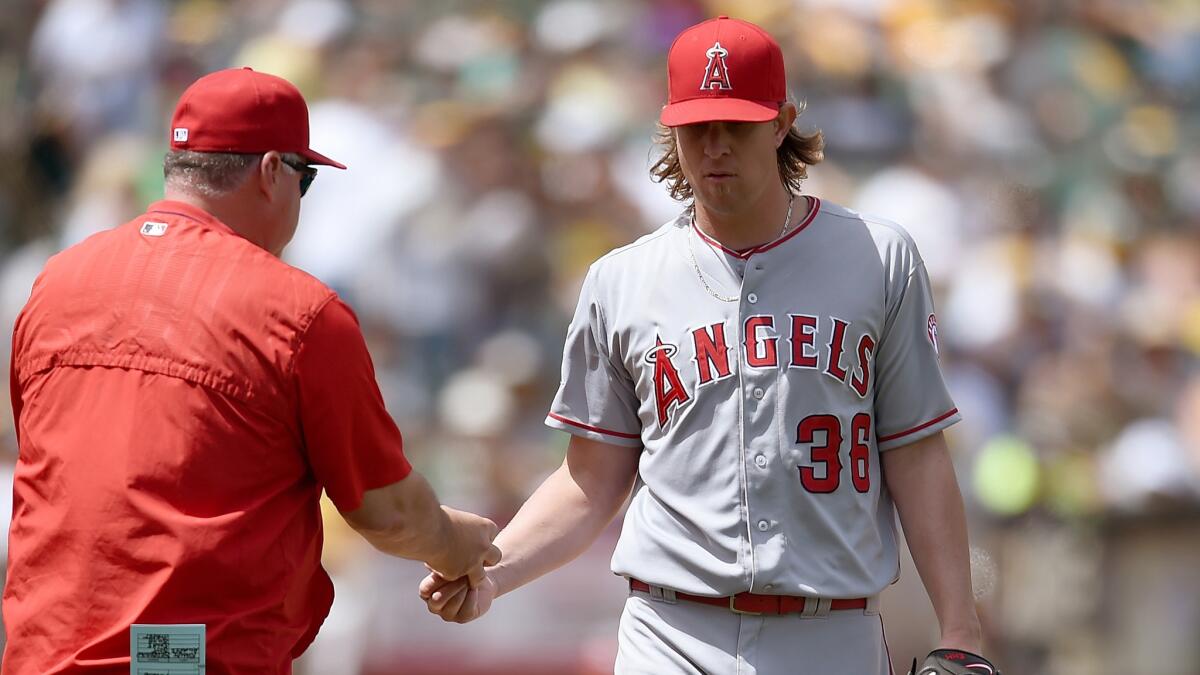 Angels Manager Mike Scioscia pulls pitcher Jered Weaver from the game during the sixth inning of a 4-1 loss to the Oakland Athletics on Saturday.