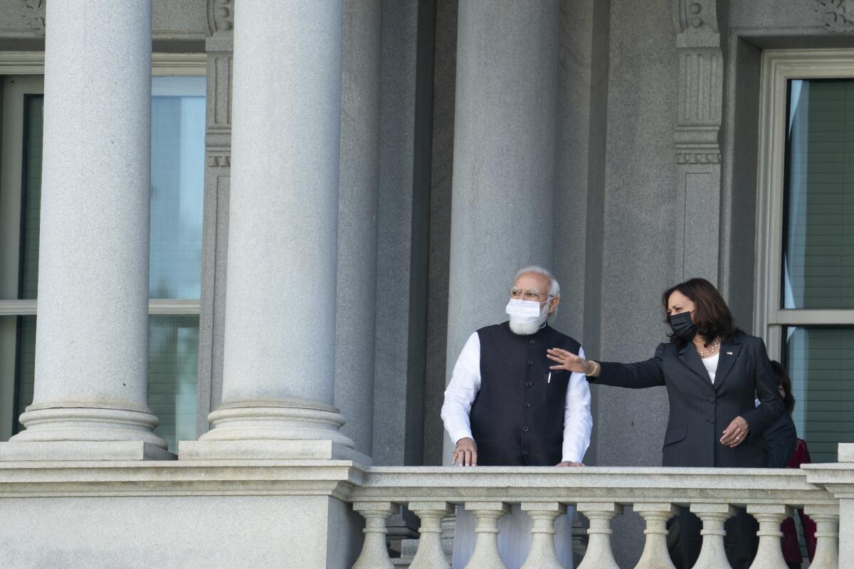 Kamala Harris talks with Narendra Modi on the balcony of the Eisenhower Executive Office Building.