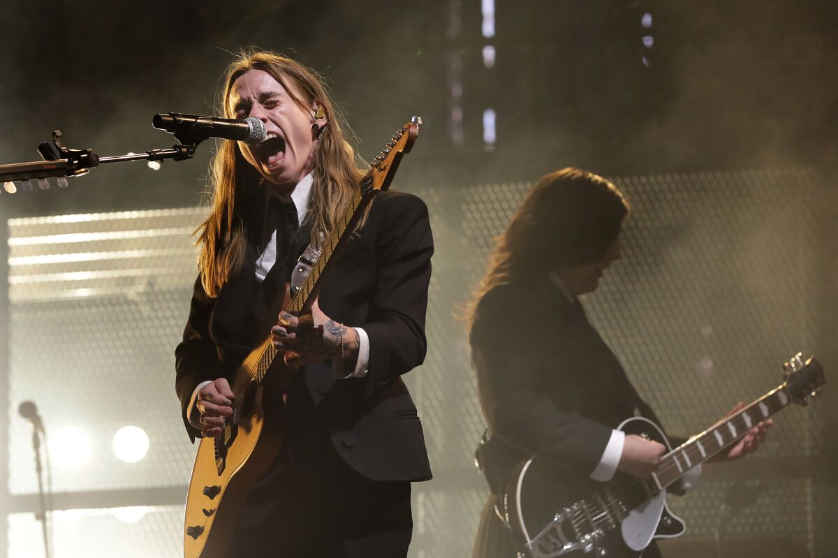 Two female rock musicians perform onstage