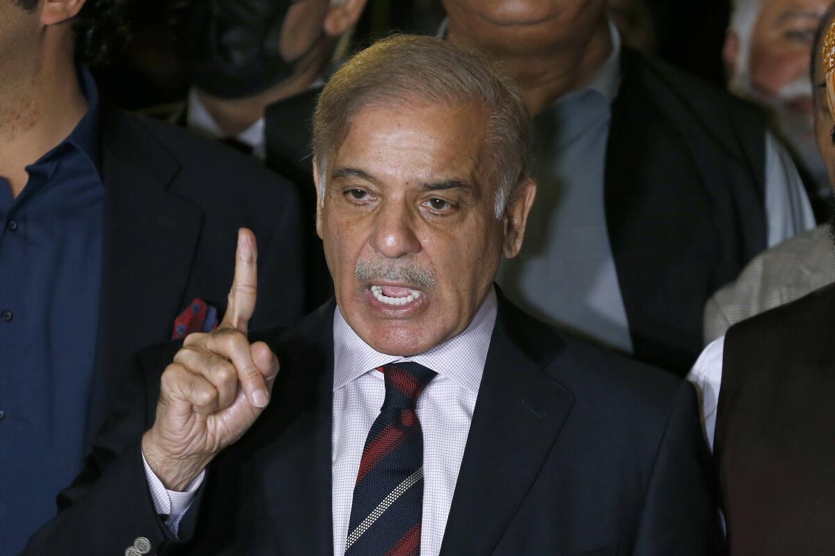 Shahbaz Sharif holds up one finger while speaking.