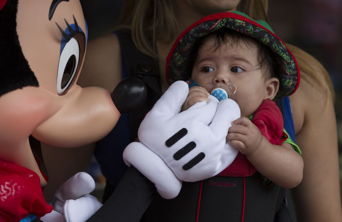 Minnie Mouse greets 5-month-old Jaxon Finney of Los Angeles at Disneyland.