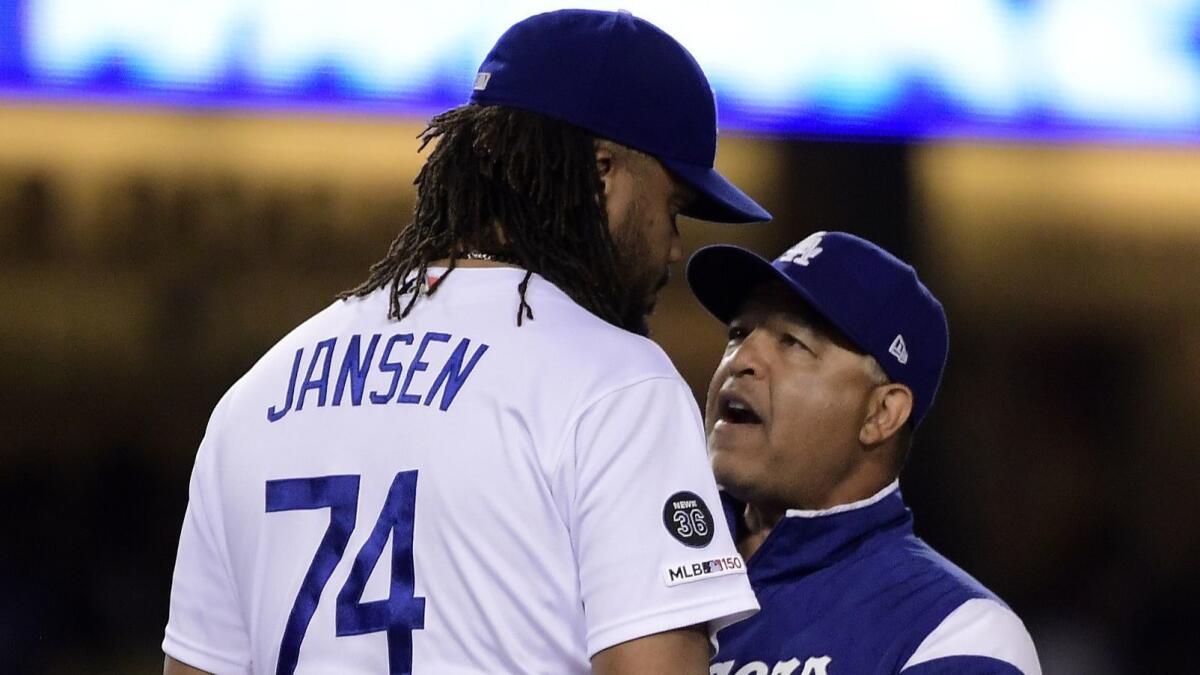 Dodgers manager Dave Roberts, right, talks to relief pitcher Kenley Jansen during the ninth inning against the San Francisco Giants ibn Thursday at Dodger Stadium.