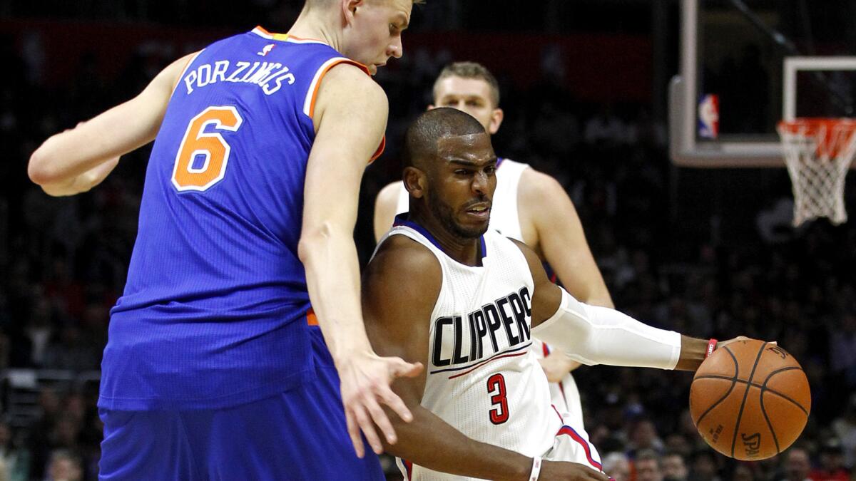 Clippers guard Chris Paul (3) tries to drive past Knicks forward Kristaps Porzingis (6) during the first half Friday night at Staples Center.