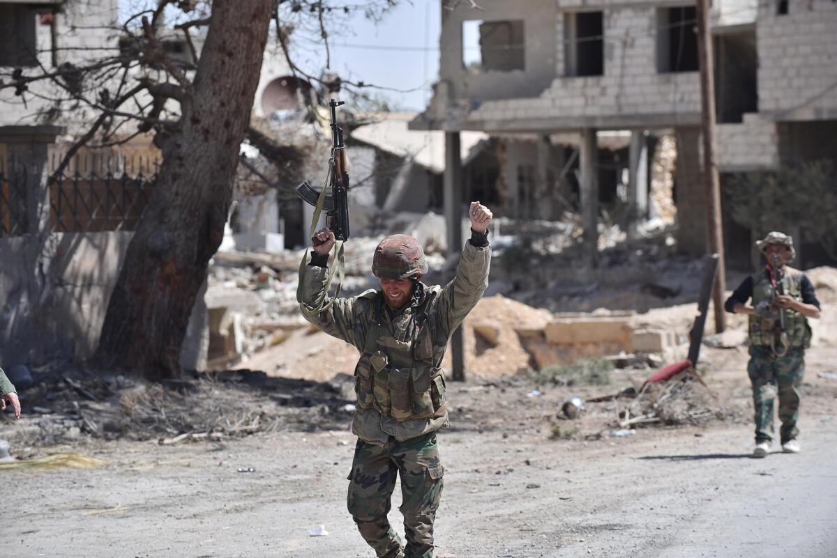 Syrian soldiers celebrate their victory against the Islamic State group in Qaryatain, Syria, on April 4.