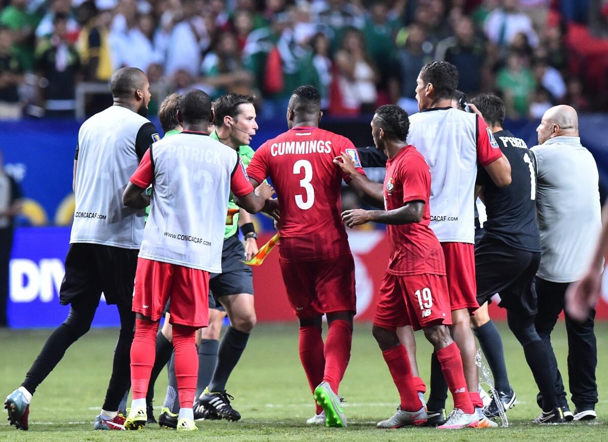 Jugadores de Panamá reclaman al árbitro Mark Geiger, tras el juego que perdieron con México.