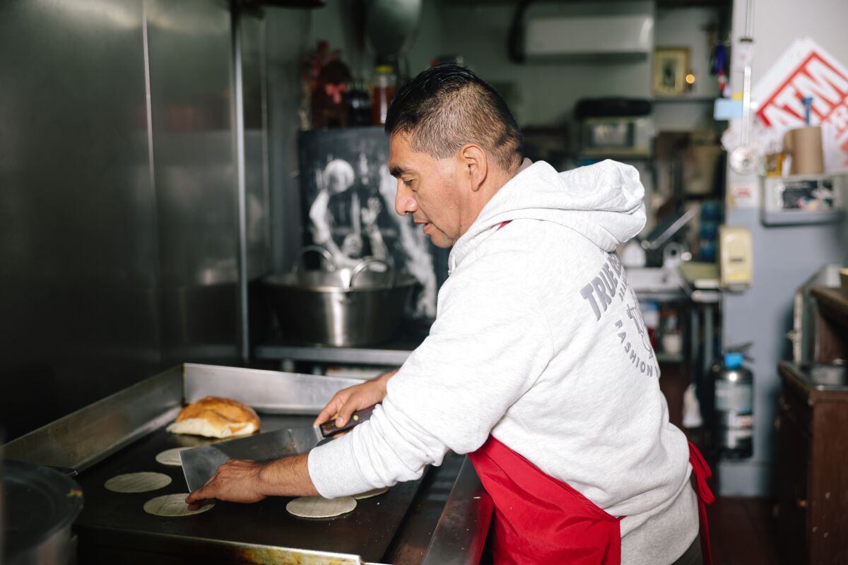 Serapia Silverio Alonso warms some tortillas at his restaurant 