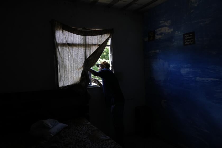 Alex Sandro Conde, 42, looks from his home at the devastation caused by a landslide at Morro da Oficina, a hillside part of Alto da Serra, Petropolis, Rio de Janeiro state, Brazil, Tuesday, Feb. 22, 2022. Conde lost his son Kaique, 18, when the place where they both worked was destroyed by a landslide after heavy rains last Tuesday. (AP Photo/Silvia Izquierdo)