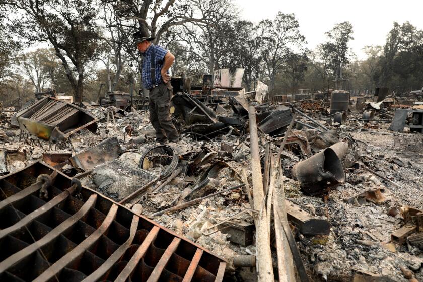 REDDING, CALIF. -- SATURDAY, AUGUST 4, 2018: Ed Bledsoe, 76, surveys his home and belongings damaged by the Carr fire along the 11000 block of Quartz Hill Rd. in Redding, Calif., on Aug. 4, 2018. Bledsoe's wife, Melody Bledsoe, 70, and his great-grandchildren, Emily Roberts, 5, and James Roberts, 4, were killed when their Redding home burned. 141,825 acres - 41% contained and 1,073 residences destroyed as of Aug. 4th. (Gary Coronado / Los Angeles Times)