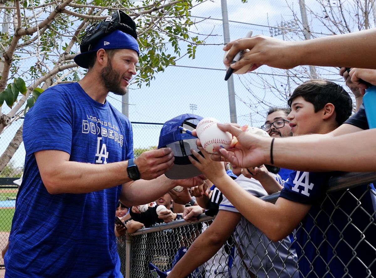 Dodgers pitcher Clayton Kershaw signs autographs after a spring training workout Sunday in Phoenix.