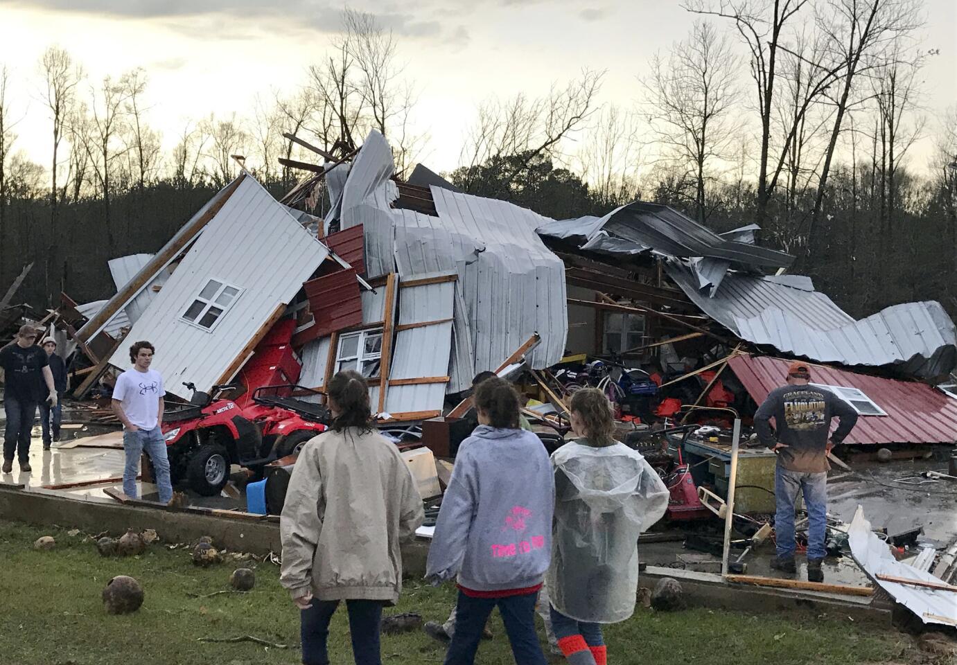 People examine a barn owned by the Miller family that was destroyed during a storm south of Mount Olive, Miss., Monday, Jan. 2, 2017.
