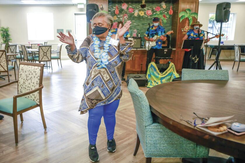 A 74-year-old woman dances to a band playing at a center that provides services and programs for seniors.