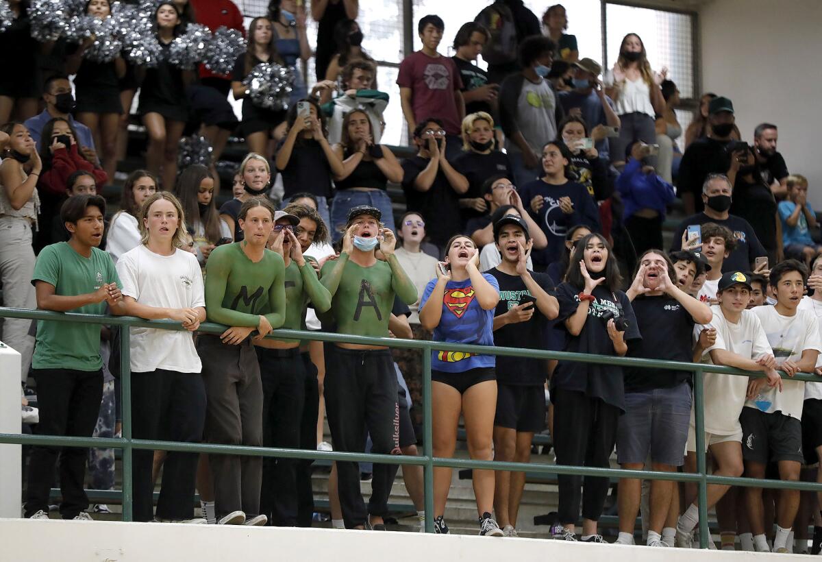 The Costa Mesa student body cheers for the girls' volleyball team as they battle crosstown rival Estancia on Thursday.
