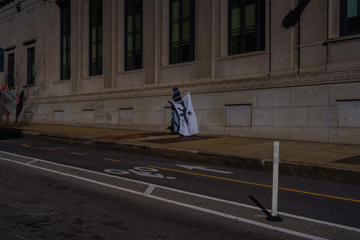A person walks with a flag in Richmond, Va., on Monday.