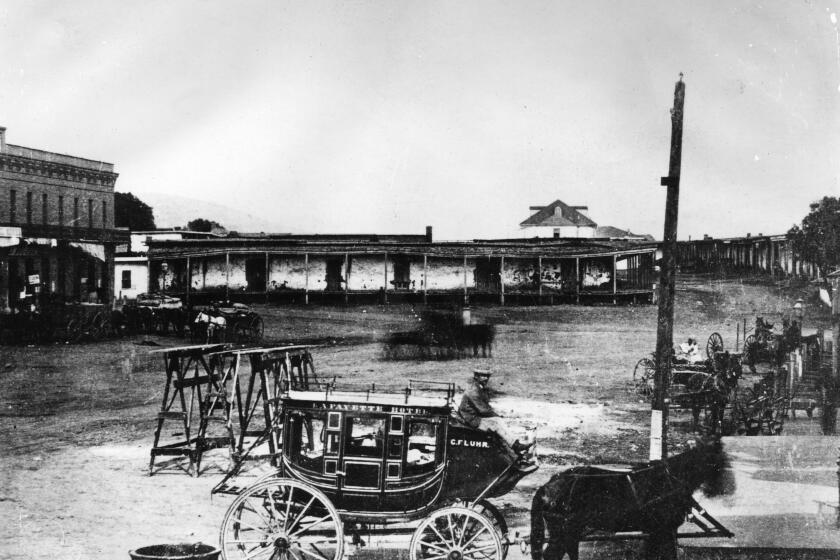 Lafayette Hotel stagecoach near the adobes in Calle de los Negros circa 1870, presently Alameda Street near Union Station and Terminal Annex Building. The old Antonio Coronel adobe is in the background.