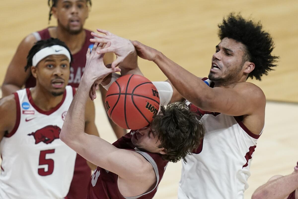 Colgate's Jack Ferguson, bottom, and Arkansas' Justin Smith, right, battle for a rebound during the second half Friday.