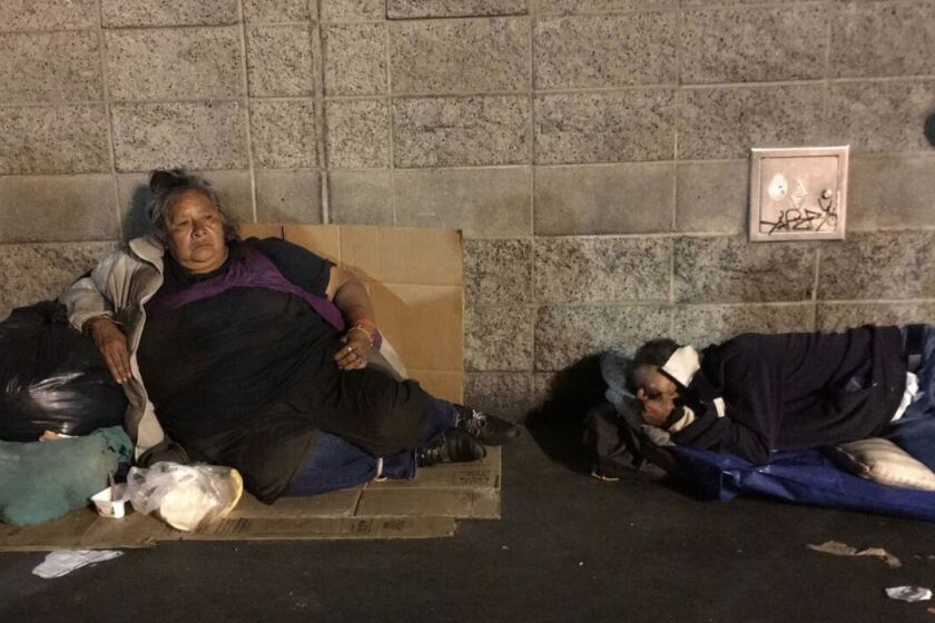 Two skid row residents rest near the Midnight Mission on San Pedro Street in downtown Los Angeles.