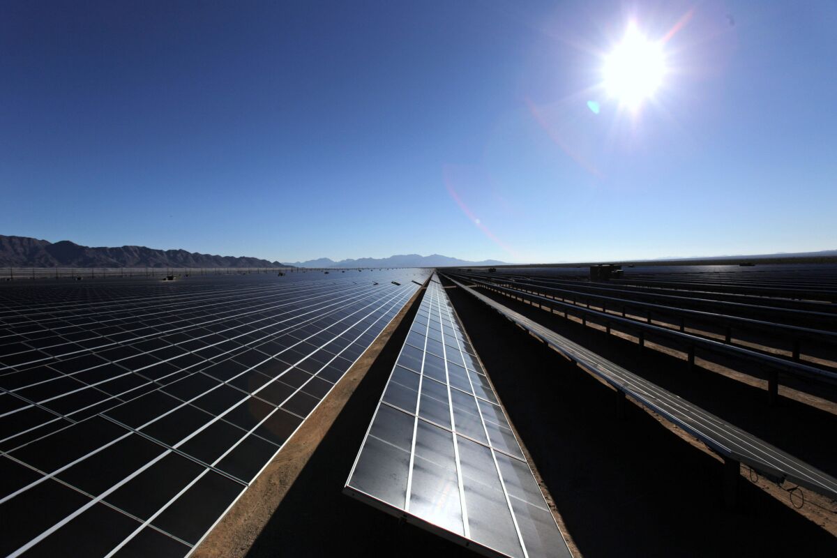 The morning sun rises over solar panels at the Desert Sunlight solar farm in Desert Center, Calif.