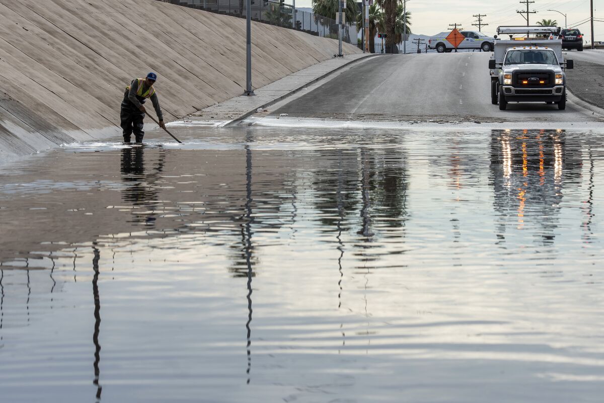 Un trabajador del Departamento de Transporte de Nevada labora para desaguar una inundación 