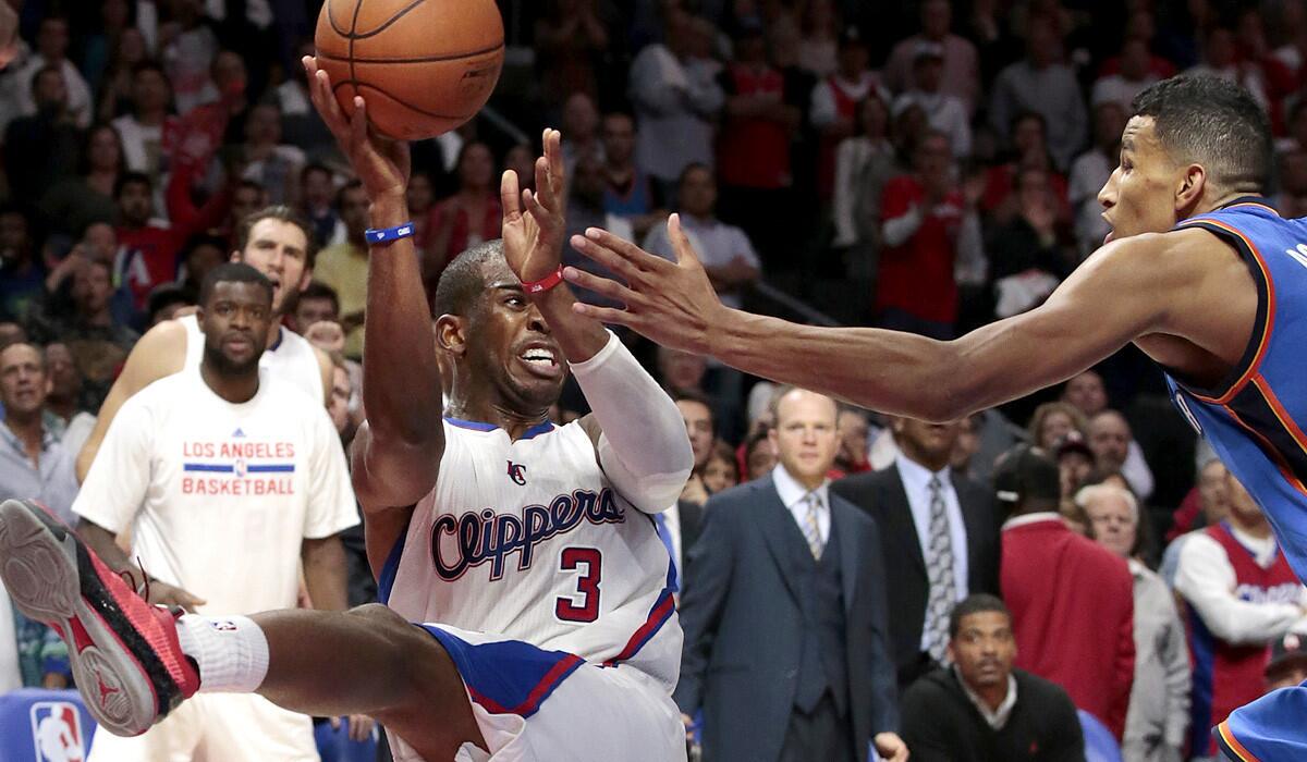 Clippers point guard Chris Paul saves the ball from going out of bounds, making a pass over Thunder guard Andre Roberson to teammate Blake Griffin (not pictured) in the final seconds of the game.