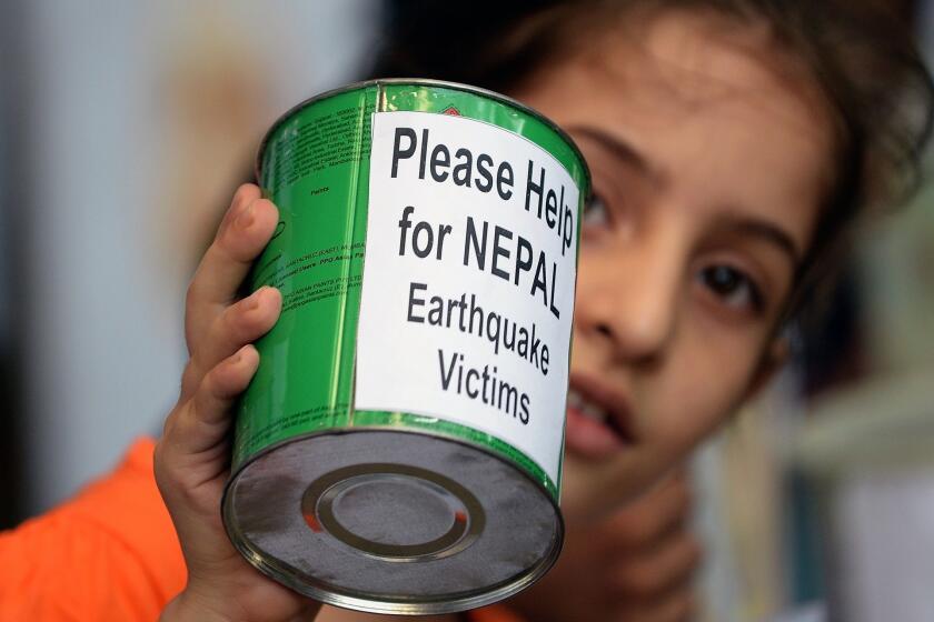 A school child in Mumbai, India, collects funds for victims of the devastating earthquake in Nepal.