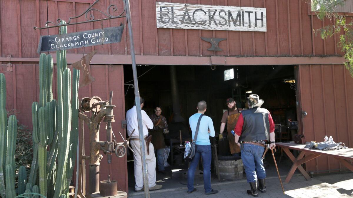 Visitors watch outside the Blacksmith shop at the Heritage Museum of Orange County.
