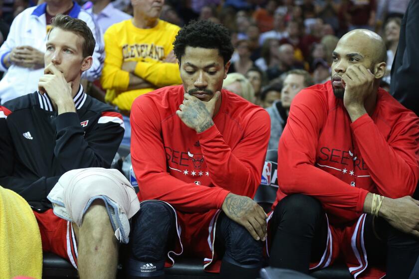 Chicago Bulls forward Mike Dunleavy, from left, guard Derrick Rose and forward Taj Gibson sit on the bench in the final seconds of Game 2. The Cleveland Cavaliers never trailed in their 106-91 victory.