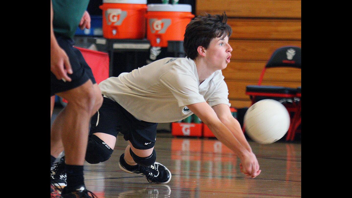 Providence's libero Zack Hurst drops to the floor to hit a serve into play against Oakwood in a boys' volleyball match at Oakwood High School in North Hollywood on Monday, April 25, 2016.