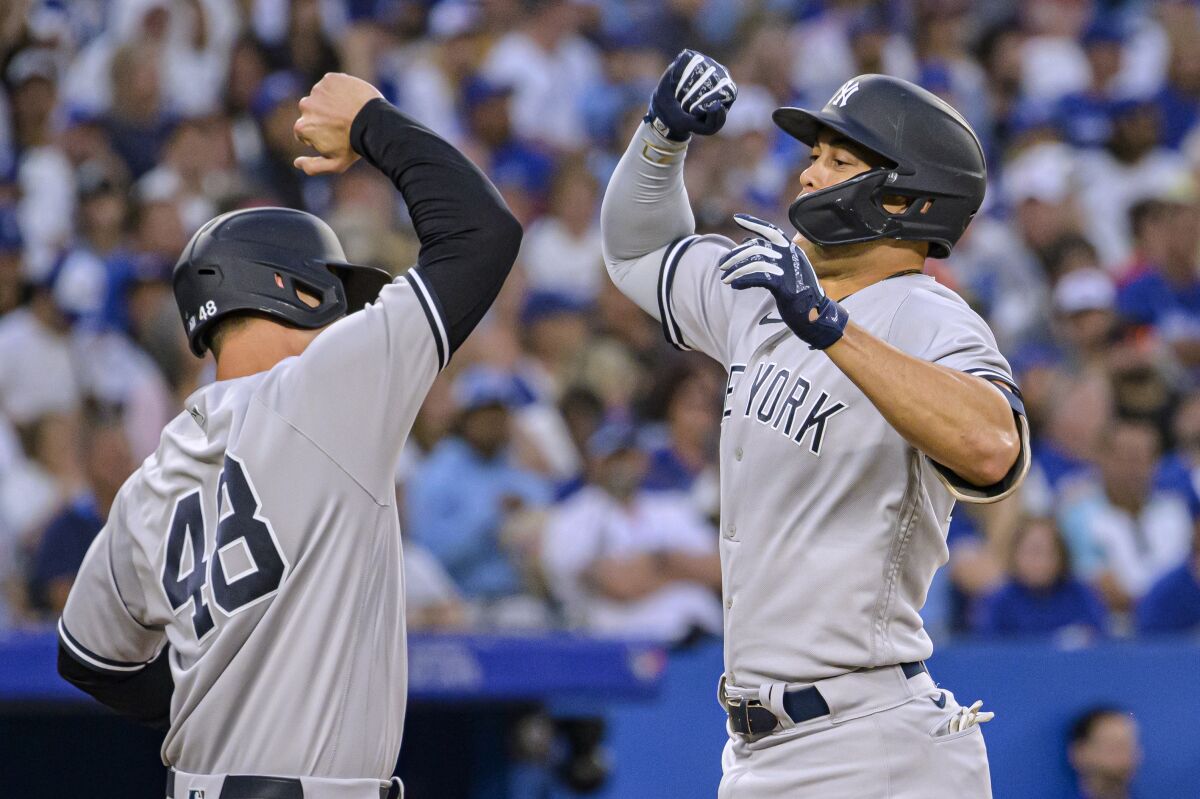 New York Yankees' Anthony Rizzo (48), and Giancarlo Stanton (27) celebrate after Stanton homered against the Toronto Blue Jays during the fifth inning of a baseball game Friday, June 17, 2022, in Toronto. (Christopher Katsarov/The Canadian Press via AP)