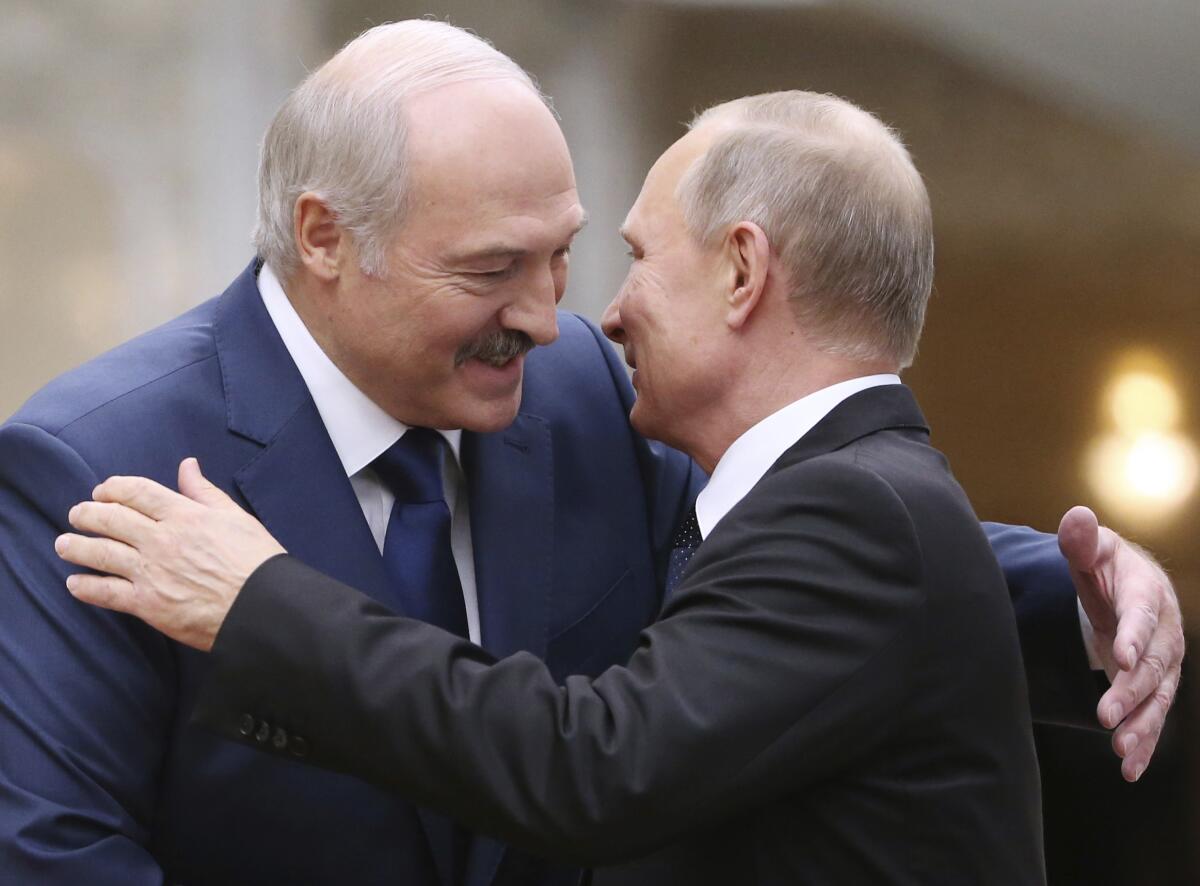 Belarusian President Alexander Lukashenko, left, greets Russian President Vladimir Putin in 2017