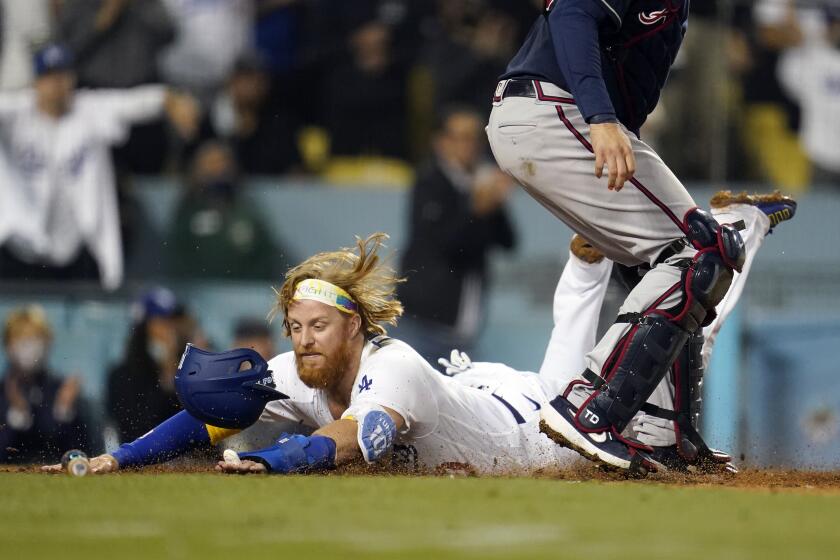 Los Angeles Dodgers' Justin Turner scores past Atlanta Braves catcher Travis d'Arnaud on a single by AJ Pollock during the eighth inning of a baseball game Wednesday, Sept. 1, 2021, in Los Angeles. (AP Photo/Marcio Jose Sanchez)