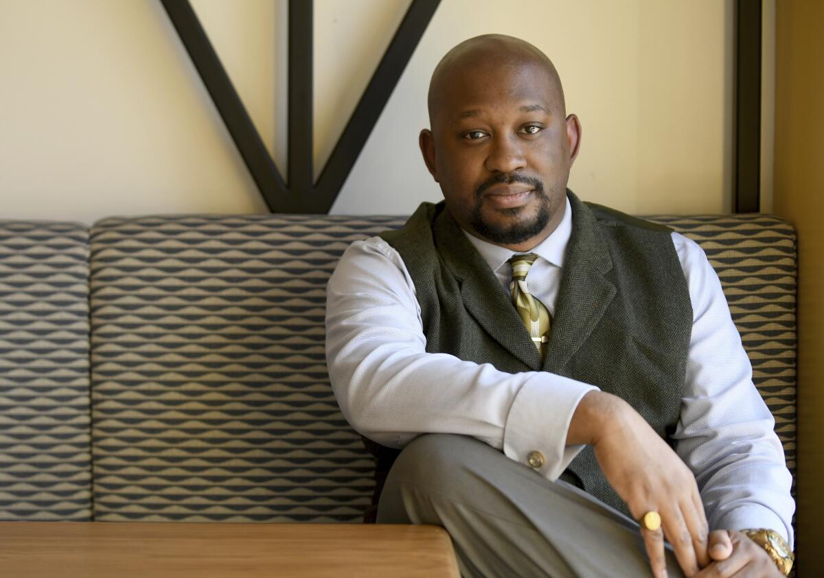 A man in a vest and tie sits at a table.