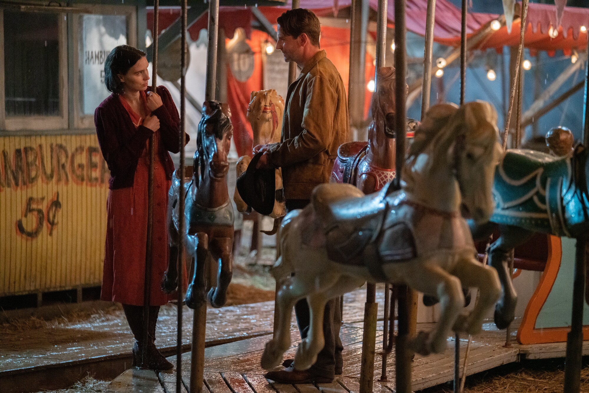 Rooney Mara and Bradley Cooper talk on a carousel in 'Nightmare Alley'