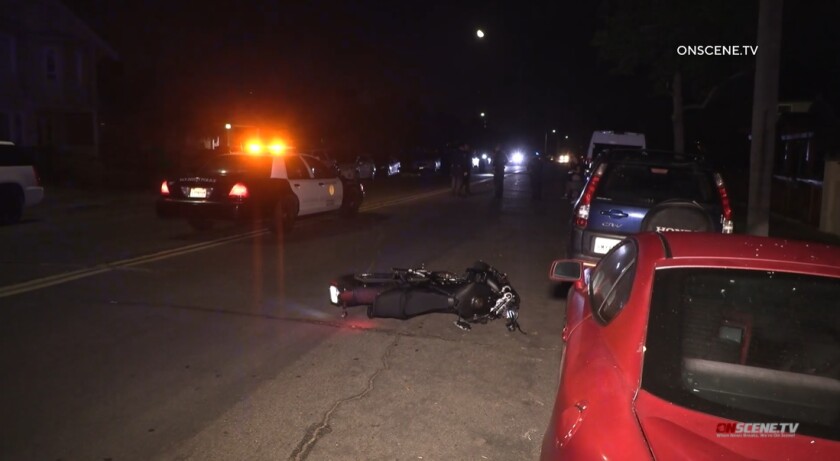 A motorcycle lies on Juniper Street late Friday after its rider was thrown off and killed in a crash with a parked car.