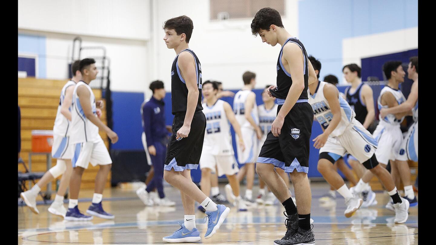 Corona del Mar's Jack Stone and Jake Hamilton walk back to the bench after losing to University during a Pacific Coast League game on Tuesday, January 9.