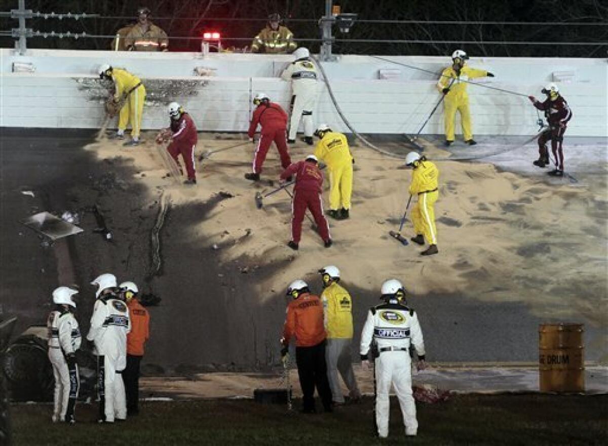 Workers clean up the track after Juan Pablo Montoya, of Colombia, crashed into a jet dryer during the NASCAR Daytona 500 auto race at Daytona International Speedway in Daytona Beach, Fla., Monday, Feb. 27, 2012. (AP Photo/Bill Friel)