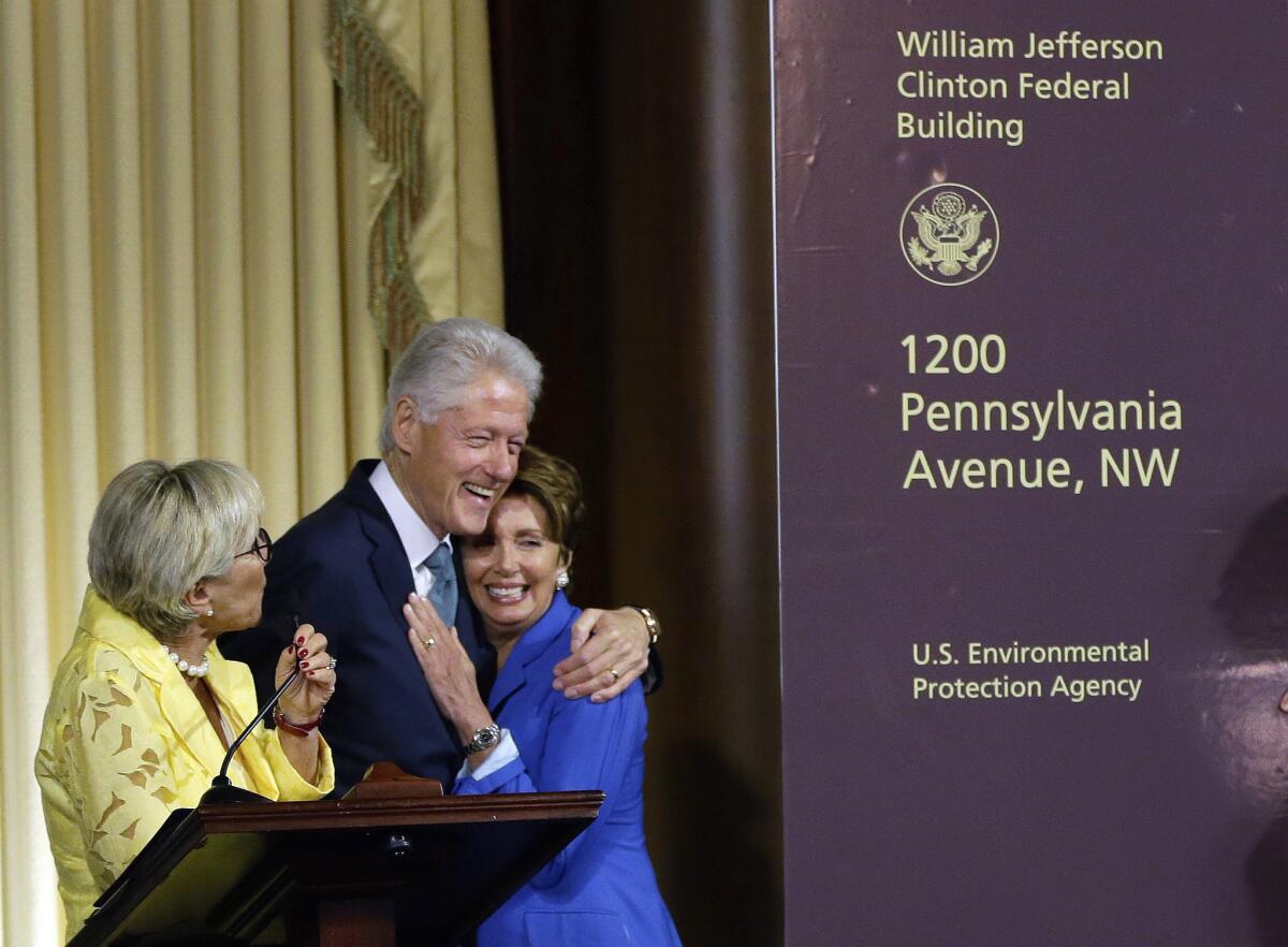 Former President Clinton hugs House Minority Leader Nancy Pelosi of California as Sen. Barbara Boxer (D-Cailf.), watches at left, during the ceremony naming the Environmental Protection Agency headquarters.