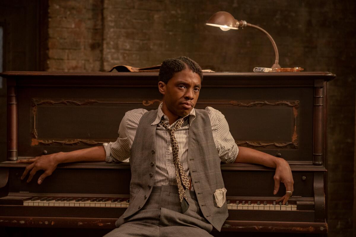 Chadwick Boseman leans against a piano as Levee