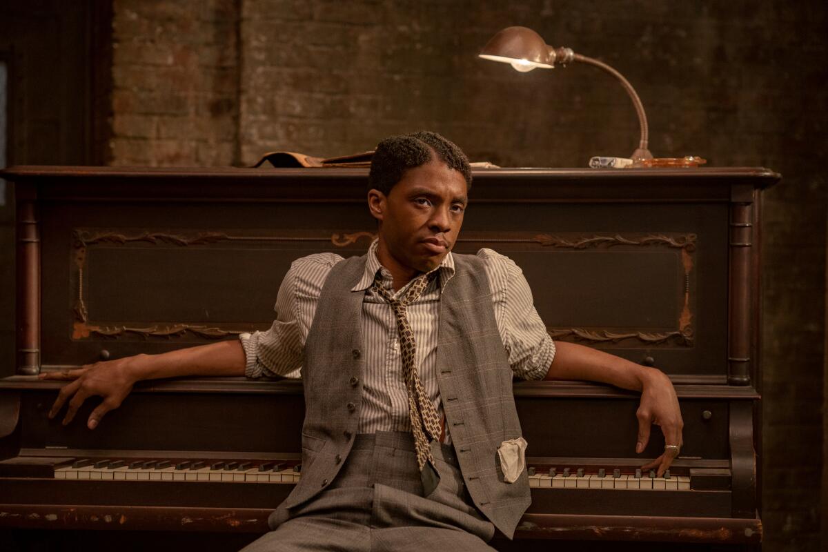 Chadwick Boseman leans against a piano as Levee