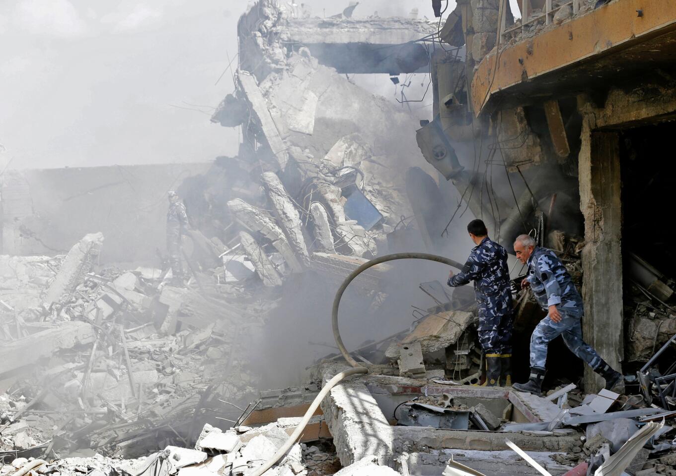 Syrian soldiers inspect the wreckage of a building described as part of the Scientific Studies and Research Centre (SSRC) compound in the Barzeh district, north of Damascus, during a press tour organized by the Syrian information ministry, on April 14, 2018. The United States, Britain and France launched strikes against Syrian President Bashar Assad's regime early on April 14, 2018, in response to an alleged chemical weapons attack after mulling military action for nearly a week.