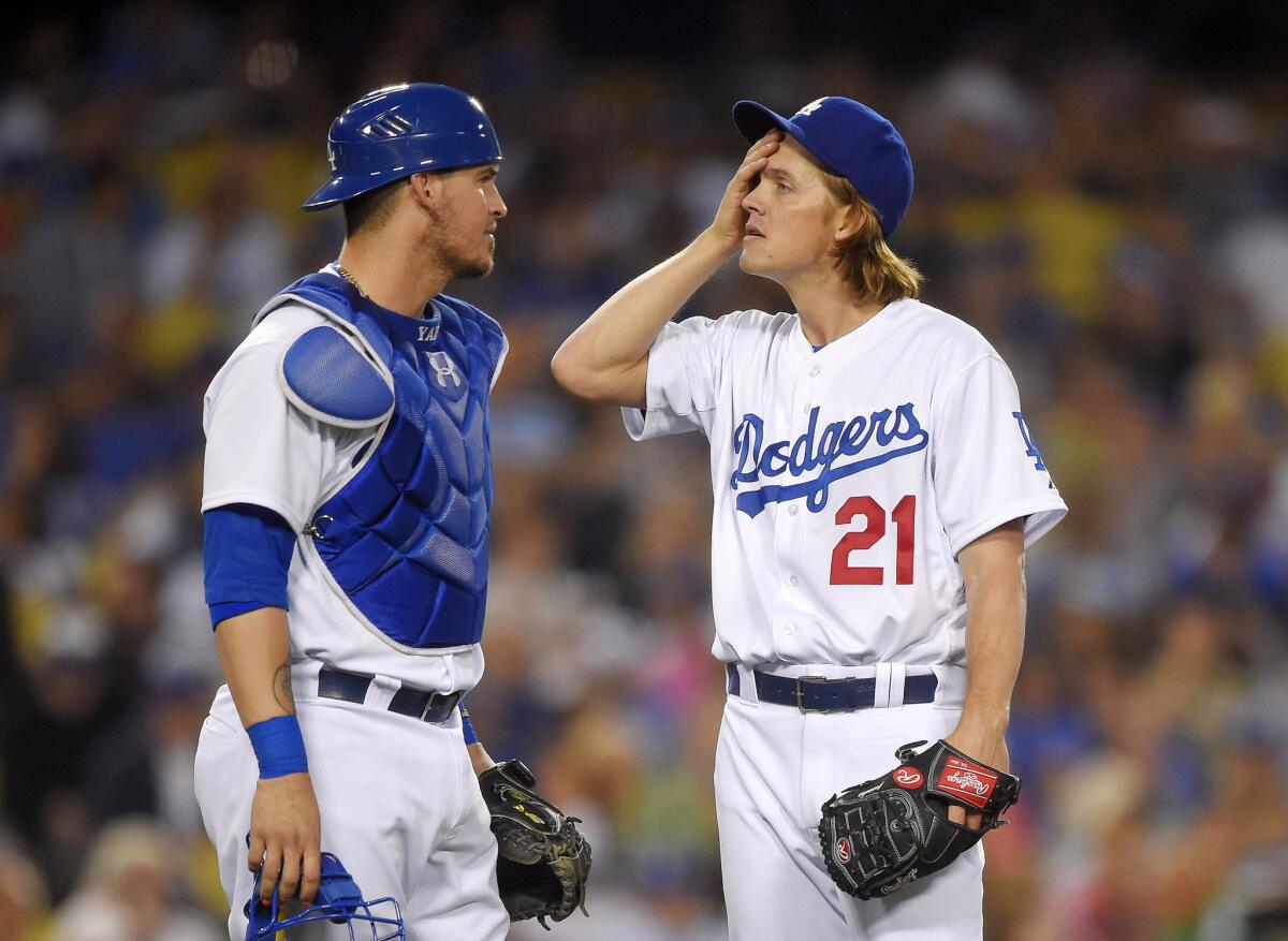 Catcher Yasmani Grandal and pitcher Zack Greinke talk during the fifth inning of the Dodgers' 1-0 win over the Texas Rangers on Thursday at Dodger Stadium.