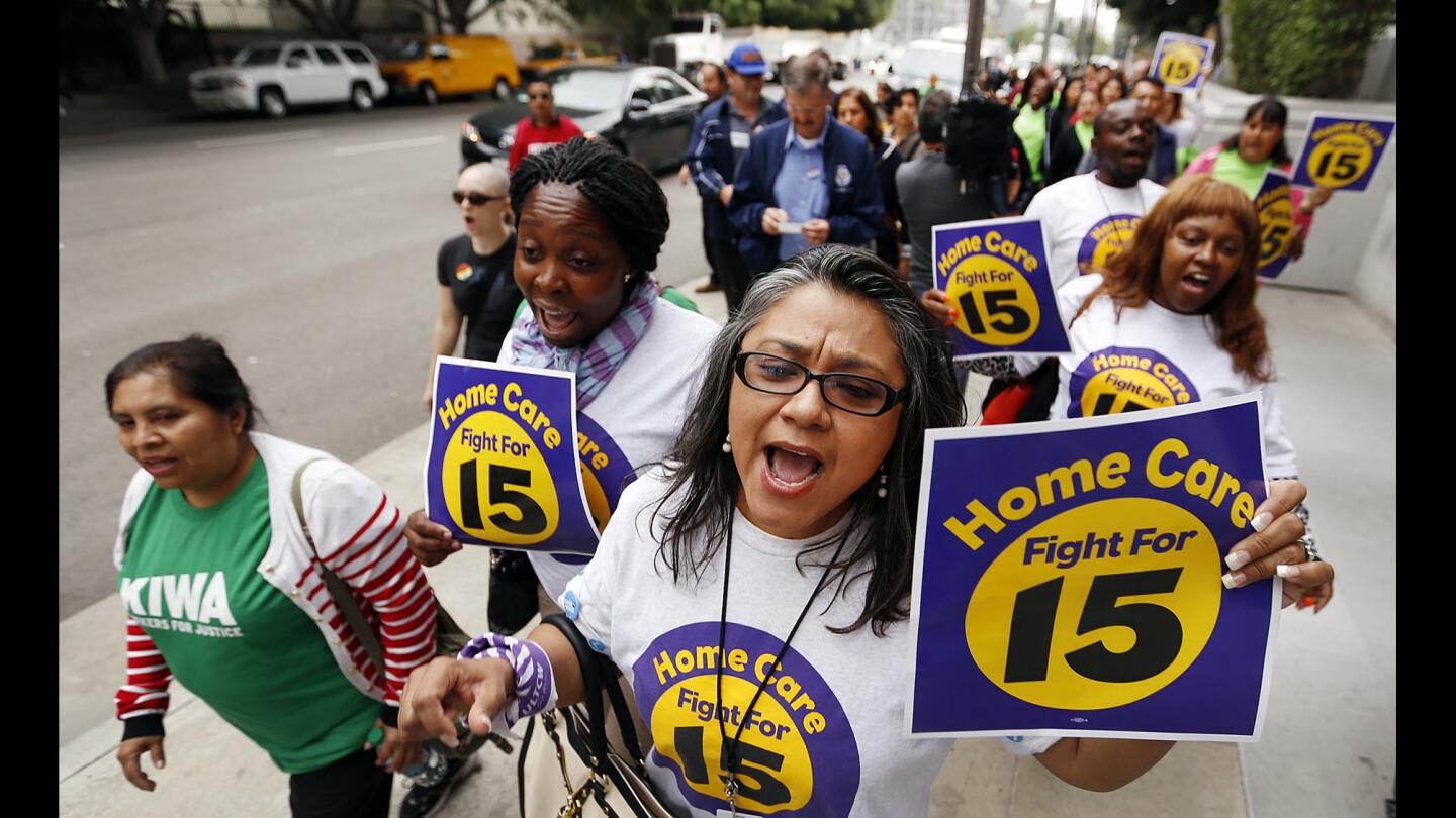 Irene Gonzalez, center, joins supporters as they march to Los Angeles City Hall before the City Council voted on an ordinance that would raise the minimum wage in Los Angeles to $15 per hour by 2020.