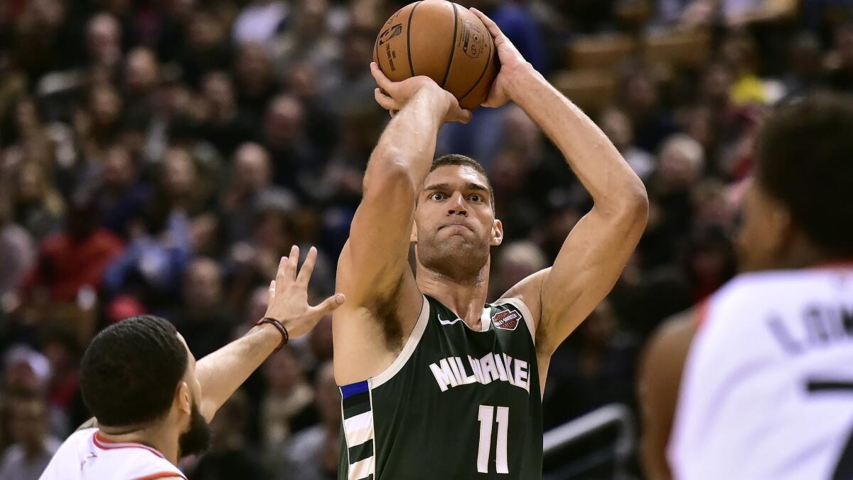 Bucks center Brook Lopez (11) lines up a three-point shot against the Raptors during a game earlier this season.