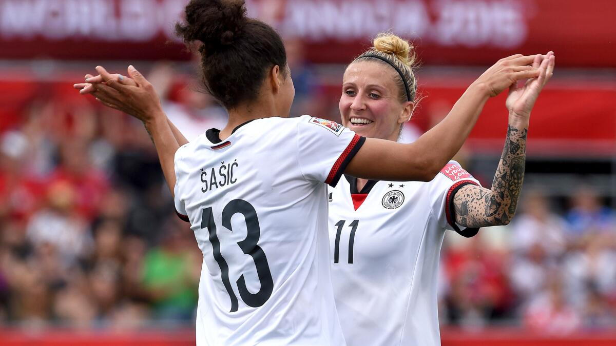 Germany's Celia Sasic (13) is congratulated by teammate Anja Mittag (11) after scoring the opening goal in their Women's World Cup group game against Ivory Coast on Sunday.