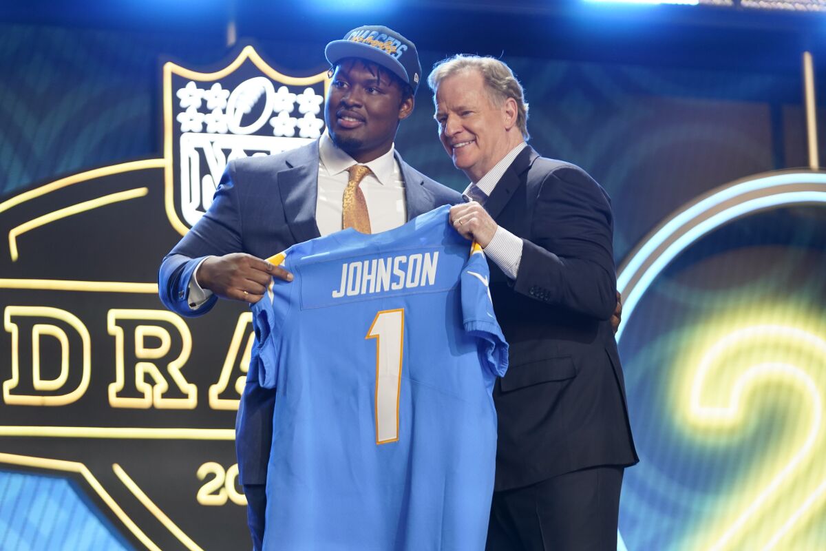 Boston College offensive guard Zion Johnson, left, and Roger Goodell.