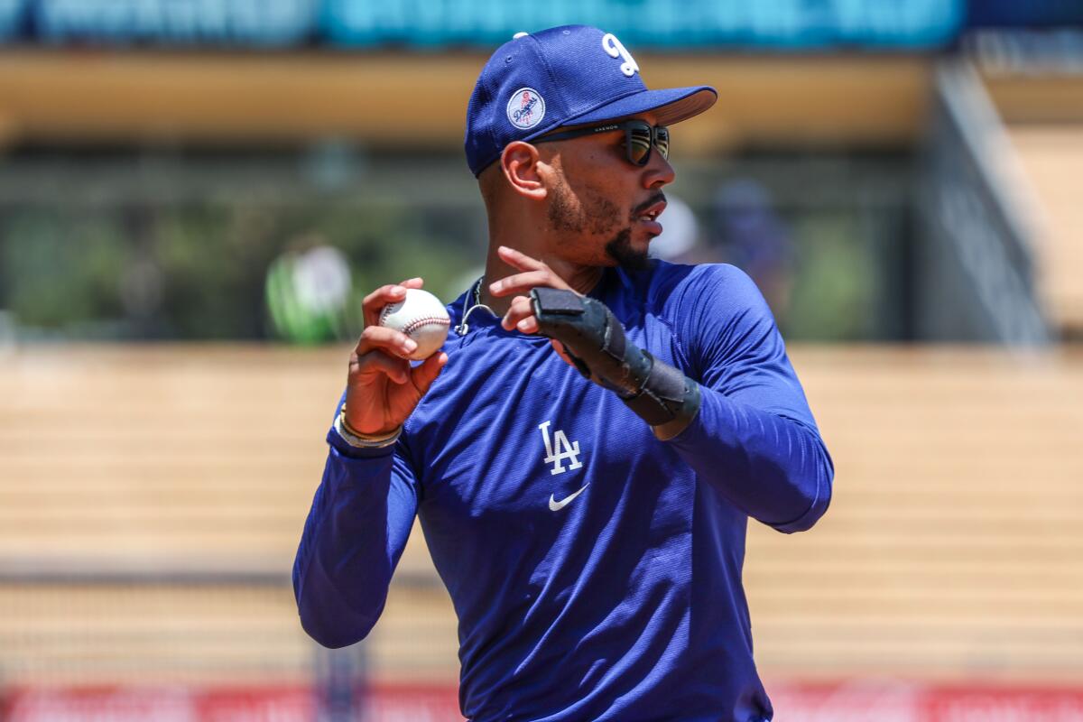 Injured Dodgers player Mookie Betts keeps his arm in shape during a workout before the game on July 6 at Dodger Stadium.