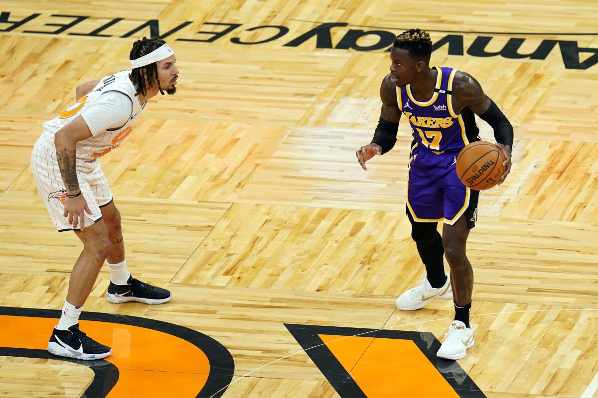 Lakers guard Dennis Schroder controls the ball in front of Orlando Magic guard Cole Anthony.