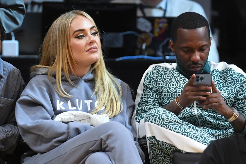 Singer Adele and boyfriend Rich Paul sit together at a basketball game